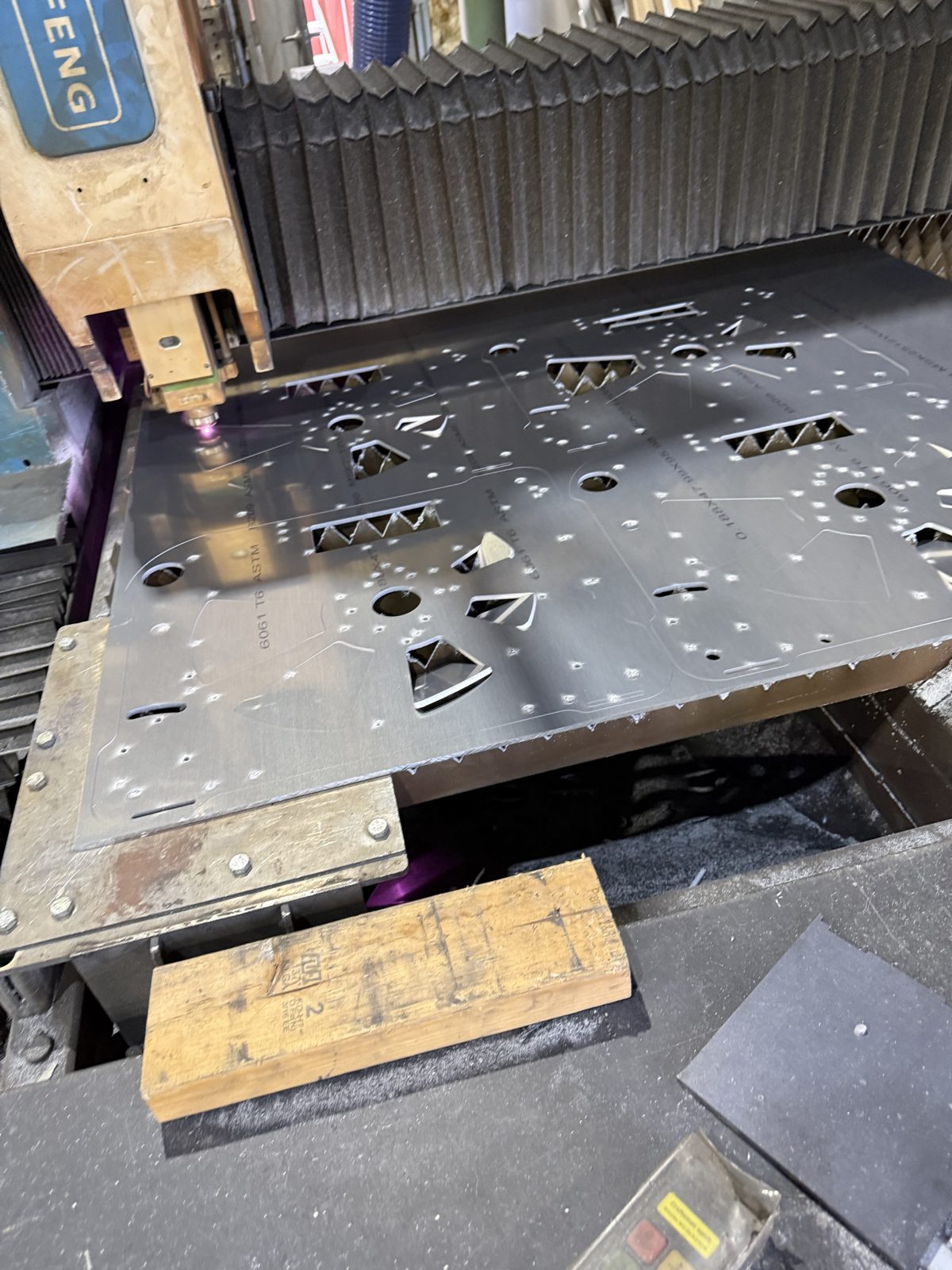 Laser head cutting a nested aluminum sheet