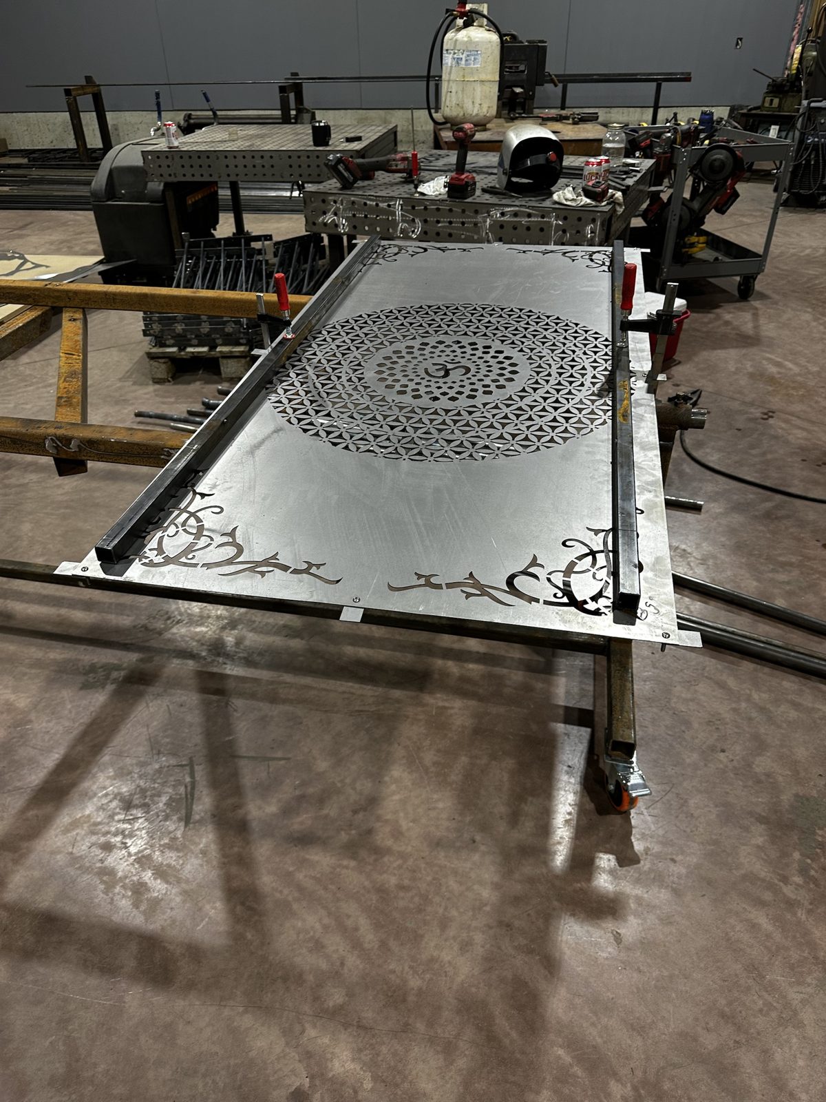 Laser-cut mandala panel being framed for a gate